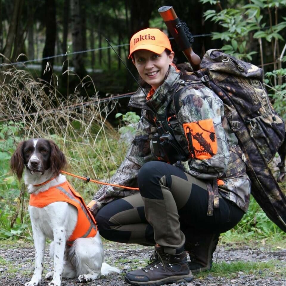 Två glada bästisar i skogen – en hund och en jägare